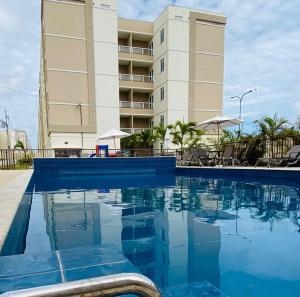 a swimming pool in front of a hotel at Apartamento Praia de Ponta com dois quartos in Natal