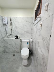 a white bathroom with a toilet and a shower at 78's Hometel Pattaya 103 in Pattaya Central