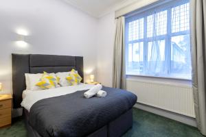 a bedroom with a bed and a large window at London Gatwick Inn in London +46 photos