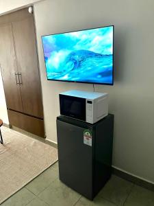 a tv sitting on top of a table with a microwave at Coaral Bells Tsavo in Kiambu