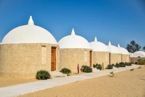 a building with domes in the middle of a desert at Gazrashek Siwa Hot spring& trips Haven in Siwa
