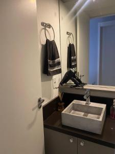 a bathroom with a sink and a mirror at AptoCentroGravataiRS in Gravataí