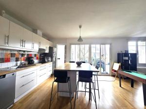 a kitchen with white cabinets and a table and chairs at la maison de caramel in Le Mans