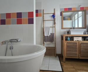 a bathroom with a tub and a sink and a mirror at la maison de caramel in Le Mans