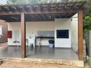 a patio with a table and chairs under a pergola at AptoCentroGravataiRS in Gravataí