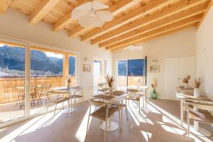 Habitación con mesas, sillas y balcón. en Hostal Lóbrega, en Torrecilla en Cameros