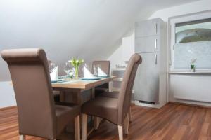 a dining room table with chairs and a refrigerator at Ferienwohnung Grauschiefer in Irsch