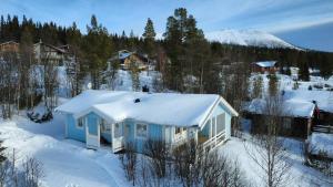 a blue house with snow on top of it at Ski-in/Ski-out | Sauna | Wi-Fi | Wood stove in Lofsdalen