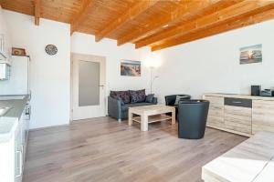 a kitchen and living room with a couch and a table at Ferienwohnung Seepferdchen für 3 Personen am Badesee Tannenhausen in Aurich