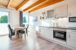 a kitchen with a table and a dining room at Ferienwohnung Seepferdchen für 3 Personen am Badesee Tannenhausen in Aurich