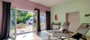 a living room with two chairs and a sliding glass door at Ahornnest in Bingerbrück