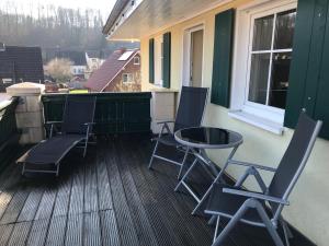 a porch with chairs and a table on a balcony at Einliegerwohnung 2 mit Garage in Beverungen