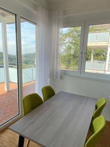 a dining room with a wooden table and green chairs at Penthouse 34 -rollstuhlgerecht- in Oerlinghausen +11 photos