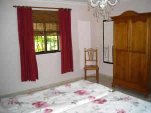 a bedroom with a bed and a window and a chandelier at Finca La Ladera in Manilva