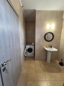 une salle de bains avec lave-linge et lavabo dans l'établissement Sunshine summer house, à Paralia Dionisiou 17 autres photos