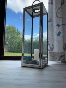 a glass lantern sitting on a table with a window at FeWo Seegras in Grödersby