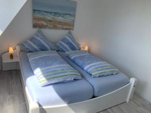 a bed with two pillows on it in a room at FeWo Seegras in Grödersby +14 photos