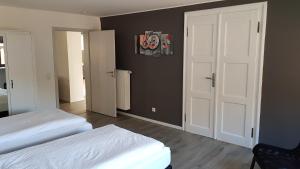 a bedroom with two beds and a white door at Ferienhaus Loreleytraum, Wohnung Erdgeschoss in Sankt Goarshausen +13 photos