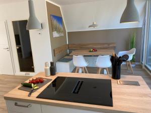 a kitchen with a counter with a table and chairs at Heimathafen Damp, Haus 9 in Damp