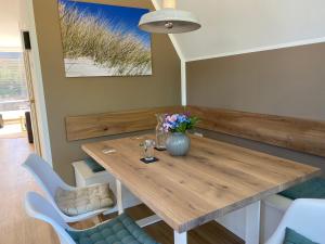 a dining room with a wooden table and chairs at Heimathafen Damp, Haus 9 in Damp