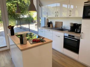 a kitchen with white cabinets and a counter top at Heimathafen Damp, Haus 9 in Damp