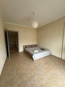 une chambre avec un lit et un sol carrelé dans l'établissement Sunshine summer house, à Paralia Dionisiou