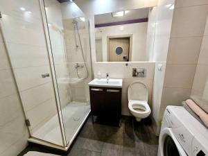 a bathroom with a shower and a toilet and a sink at Extra Green Kabaty Apartament nr 5 in Warsaw +12 photos