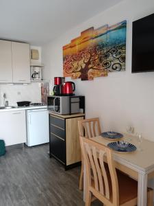 eine kleine Küche mit Tisch und Mikrowelle in der Unterkunft Balaruc studio avec piscine parking et climatisation in Balaruc-les-Bains