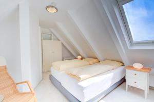 - une petite chambre mansardée avec un lit et une chaise dans l'établissement Abaco 2N, à Wenningstedt