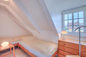 une petite pièce avec un lit et une fenêtre dans l'établissement Abaco 2N, à Wenningstedt
