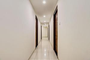 an empty corridor with white walls and white tile floors at Dream Comforts Lodging & Boarding in Bengaluru