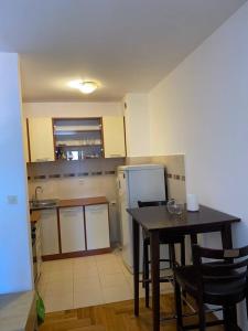 a kitchen with a table and chairs and a refrigerator at Filip apartment in Podgorica