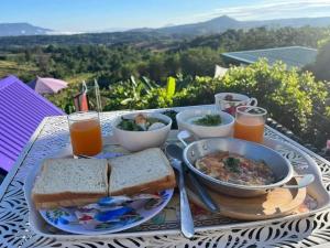 a table with a plate of food and a bowl of soup at บ้านไร่เก็บตะวันโฮมสเตย์น้ำหนาว in Ban Phu Hi