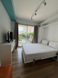 a bedroom with a bed and a large window at Flat Wise Confort in São Paulo