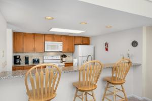 a kitchen with two chairs and a counter with a refrigerator at Ocean State of Mind in Edisto Island