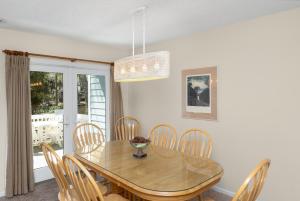a dining room with a wooden table and chairs at Ocean State of Mind in Edisto Island +23 photos