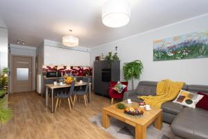 een woonkamer met een bank en een tafel bij Apartament Atena - Beskid Apartment in Szczyrk