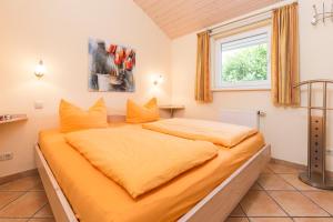 a bedroom with a large bed with yellow sheets at Haus im Apfelgarten 1 in Fehmarn