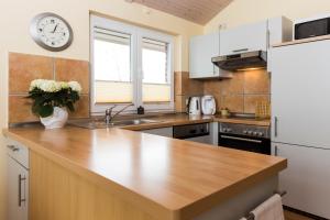 a kitchen with a counter and a clock on the wall at Haus im Apfelgarten 1 in Fehmarn