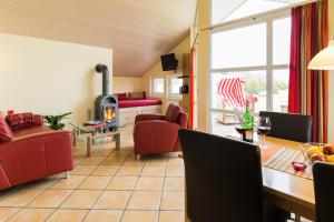 a living room with red furniture and a fireplace at Haus im Apfelgarten 1 in Fehmarn +1 photo