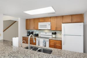a kitchen with wooden cabinets and a white refrigerator at Ocean State of Mind in Edisto Island