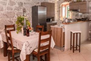 a kitchen with a table with chairs and a refrigerator at Holiday Home in Podgora +32 photos