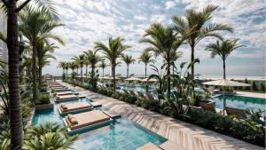 een zwembad met ligstoelen en palmbomen bij فندق الهم هم in Basaksehir