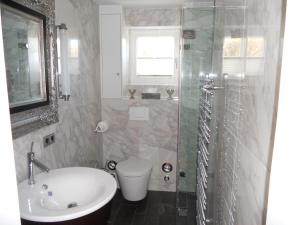 a bathroom with a sink and a toilet and a shower at Ferienwohnung Sönshörn S8R In Munkmarsch in Munkmarsch