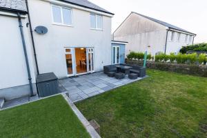 a backyard of a white house with a patio at Piran View in Perranporth