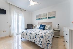 a white bedroom with a bed and a window at MalagaSuite El Levante Apartments in Torremolinos