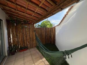 a hammock in a room with a fence at La Fluorita Hospedaria in Morro do Chapéu