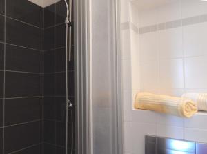 a bathroom with a shower with a towel on the wall at Resi K6 in Prerow