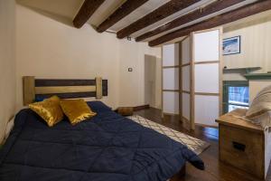 une chambre avec un grand lit bleu avec des oreillers dorés dans l'établissement Antiba House, à Ferrare