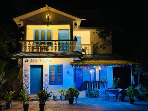 a white house with a balcony at night at Hello entire villa varkala cliff in Varkala